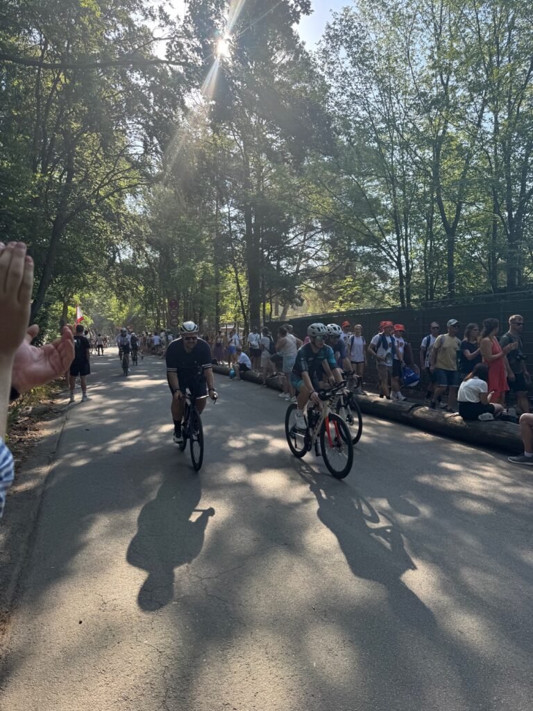 Radfahrer auf der Waldstrecke, Zuschauer klatschen am Streckenrand
